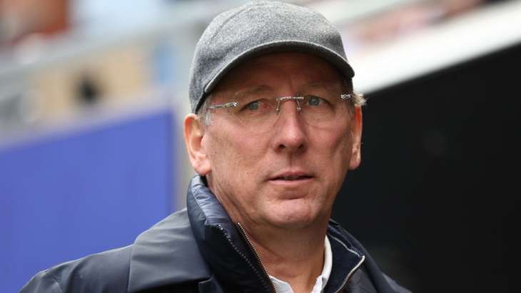 John Textor, casquette et lunette, sous la pluie